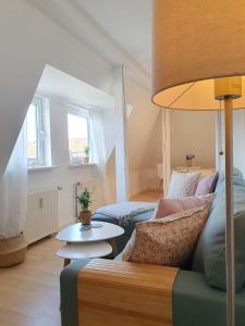 un soggiorno con divano e tavolo di Charmante Maisonnette-Dachgeschosswohnung in zentraler Lage a Rostock