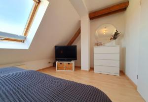 a bedroom with a bed and a tv in a attic at Charmante Maisonnette-Dachgeschosswohnung in zentraler Lage in Rostock