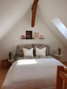 una camera da letto con un grande letto con lenzuola bianche di Charmante Maisonnette-Dachgeschosswohnung in zentraler Lage a Rostock