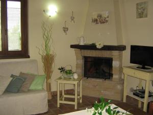 - un salon avec un canapé et une cheminée dans l'établissement Ferienwohnung Sonnenblumen, à Cagli