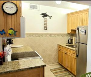 a kitchen with a refrigerator and a clock on the wall at Paradise awaits you at Key Colony Beach in Key Colony Beach