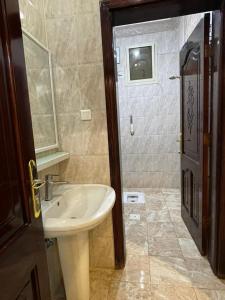 a bathroom with a sink and a mirror and a shower at شالية الفوز in Al Madinah