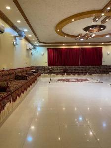 شالية الفوز في المدينة المنورة: صالة فاضية فيها مسرح وستائر حمراء