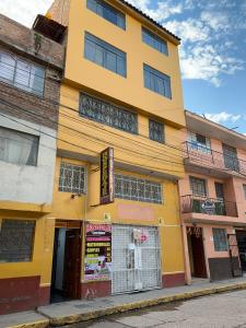 un edificio amarillo al lado de una calle en Hospedaje Luciano, en Ayacucho