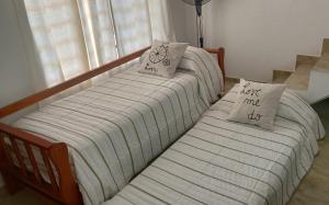 Duas camas com almofadas num quarto em Duplex Atenea em Chivilcoy