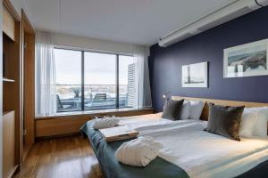 a bedroom with two beds and a large window at Scandic Alvik in Stockholm