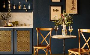 a table with two chairs and a vase with flowers at The Hotel Chalet at The Choo Choo in Chattanooga