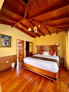 1 dormitorio con 1 cama grande y suelo de madera en Hotel Mabey Urubamba, en Urubamba