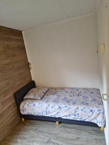una piccola camera da letto con un letto ad angolo di Chalet met hottub a Lanaken