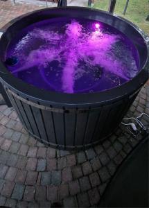 a purple bath tub sitting on a brick ground at Chalet met hottub in Lanaken