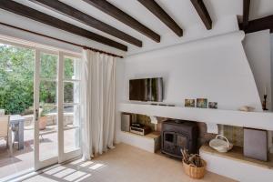 a living room with a fireplace and a tv at Villa Cala Padri Seafront home in Capdepera
