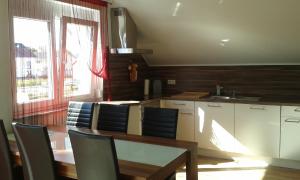 Una cocina con mesa y sillas y una ventana. en Ferienwohnung Valerie, en Ettenheim