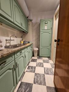 a kitchen with green cabinets and a checkered floor at VILLAGE SINTRA gh in Sintra