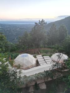 Tienda blanca y sillas en la cima de una colina en NOMAD Domes Sky Watching at Jarabacoa, en Jarabacoa