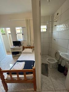 a bedroom with a bed and a toilet and a sink at Pousada Quartos vcp in Viracopos