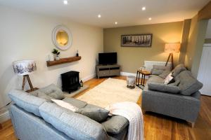 a living room with two couches and a television at Oak Tree Barn in Pickering