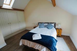 a bedroom with a large bed with blue pillows at Oak Tree Barn in Pickering