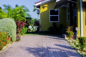 a brick driveway leading to a green house at Ocho Rios Drax Hall Manor 3 Bed Getaway in Mammee Bay