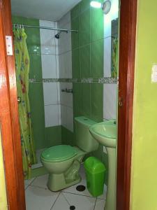 baño verde con aseo y lavamanos en Hospedaje Luciano, en Ayacucho