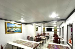 un restaurant avec des tables et des chaises et une peinture murale. dans l'établissement MIRKA HOTEL LUX, à Samarcande