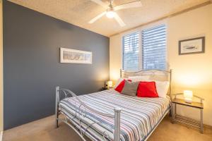 Un dormitorio con una cama con almohadas rojas. en 14 The Dunes large unit with pool tennis court and directly across from Fingal beach, en Fingal Bay 20 fotos más