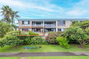 una vista exterior de un edificio con árboles en 14 The Dunes large unit with pool tennis court and directly across from Fingal beach, en Fingal Bay