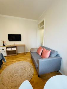 Your Chic Vibrant Airbnb في هلسنكي: غرفة معيشة مع أريكة وتلفزيون بشاشة مسطحة