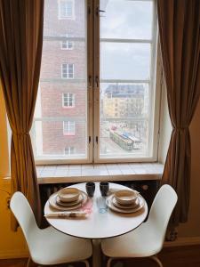 Your Chic Vibrant Airbnb في هلسنكي: طاولة وكرسيين أمام النافذة