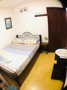 a small bedroom with a bed and a door at AptoPuntoCentro Santa Marta in Santa Marta