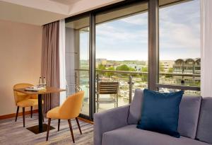 a living room with a couch and a table and a balcony at DoubleTree by Hilton Lincoln in Lincoln