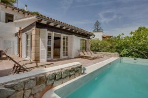a house with a swimming pool and a patio at Villa Cala Padri Seafront home in Capdepera