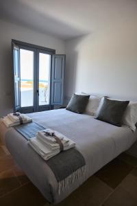 Un dormitorio con una cama grande con toallas. en Cala Sala Suite Sun & Sea, en Polignano a Mare