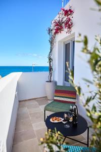 una mesa y una silla en un balcón con vistas al océano en Cala Sala Suite Sun & Sea, en Polignano a Mare