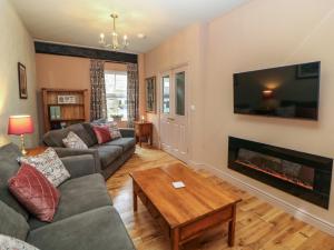 a living room with a couch and a fireplace at Corner Cottage in Buxton