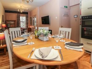a dining room with a wooden table and chairs at Corner Cottage in Buxton