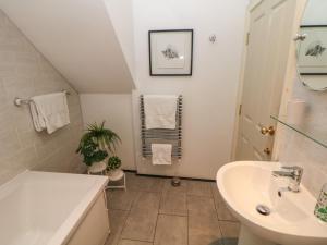 a white bathroom with a sink and a toilet at Corner Cottage in Buxton +19 photos