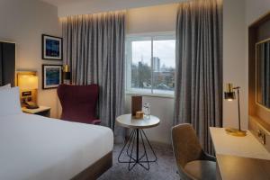 a hotel room with a bed and a table and a window at DoubleTree by Hilton London Angel Kings Cross in London