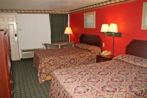 a hotel room with two beds and red walls at Lone Star Inn Llano in Llano