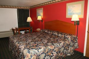a hotel room with a bed and a red wall at Lone Star Inn Llano in Llano