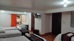 pokój hotelowy z 2 łóżkami i oknem w obiekcie Tierra Mágica Hostal w Machu Picchu
