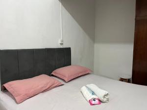 a bed with two pillows and two towels on it at Apartamento no Centro de Blumenau in Blumenau