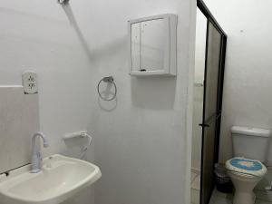 a white bathroom with a sink and a toilet at Apartamento no Centro de Blumenau in Blumenau