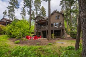une maison dans les bois avec des chaises rouges dans la cour dans l'établissement Suncadia 4 Bed Fairway View Lodge, à Cle Elum