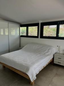 sypialnia z dużym łóżkiem i 3 oknami w obiekcie Saloniky Garden w mieście Holon