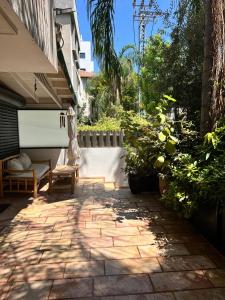 a patio with a bench and some plants at Saloniky Garden in H̱olon