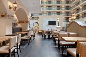 un restaurante con mesas, sillas y TV en Embassy Suites by Hilton Los Angeles International Airport South, en El Segundo