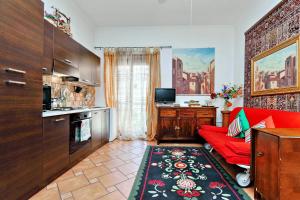 a living room with a red couch and a kitchen at The Roman Nest in Rome
