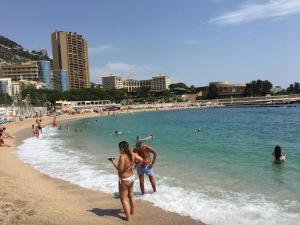 un hombre y una mujer de pie en una playa en Princess Palace Larvotto Beach Monte-Carlo en Montecarlo