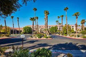 een parkeerplaats voor een gebouw met palmbomen bij DoubleTree by Hilton Golf Resort Palm Springs in Cathedral City