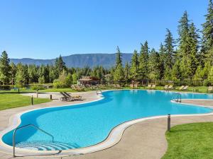 a large swimming pool in a park with trees at Suncadia 5 Bdrm Home Nestled in the Forest in Cle Elum